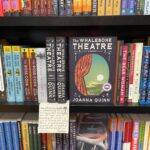 Copies of The Whalebone Theatre on a shelf surrounded by other novels.