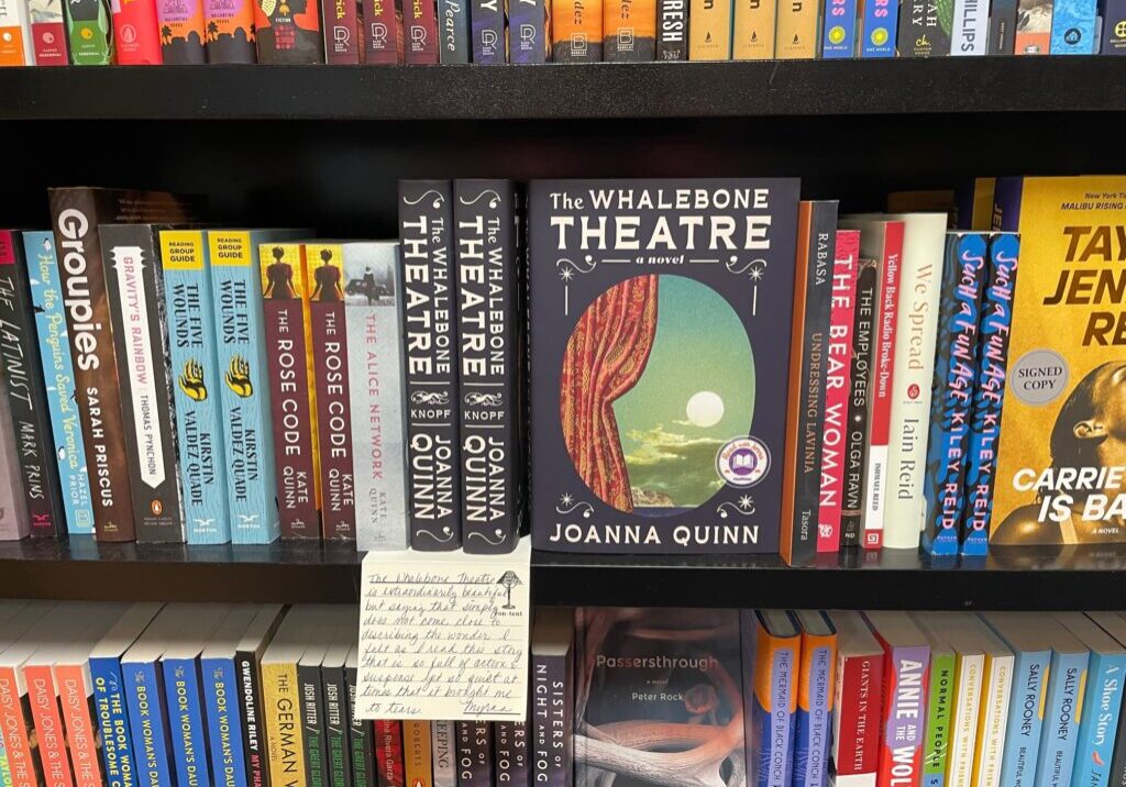 Copies of The Whalebone Theatre on a shelf surrounded by other novels.
